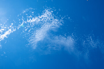 
White clouds in the blue sky. Light, cirrus, weightless, melting clouds in the sky on a sunny day.