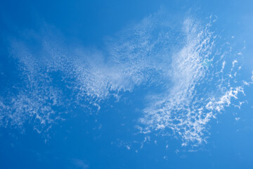 
White clouds in the blue sky. Light, cirrus, weightless, melting clouds in the sky on a sunny day.