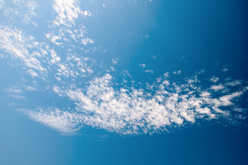 
White clouds in the blue sky. Light, cirrus, weightless, melting clouds in the sky on a sunny day.