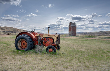 Old tractor and grain elevator at the town of Dorothy in the Alberta badlands near Drumheller