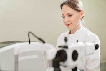 doctor examines eyes on screen of autorefractometer. 