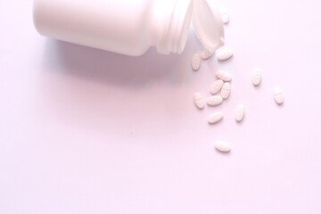 White pills and pill bottles were placed on a white table.