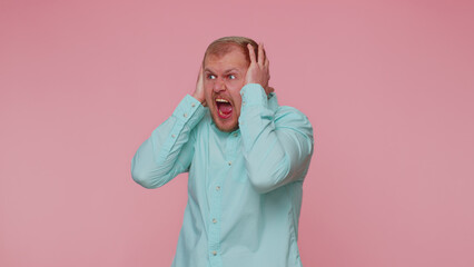 Bearded adult man scared fearful, covering ears with hands, closing eyes, meeting his own phobia, evidence horror event, screaming, shouting at loud, freaked out. Young guy alone on pink background