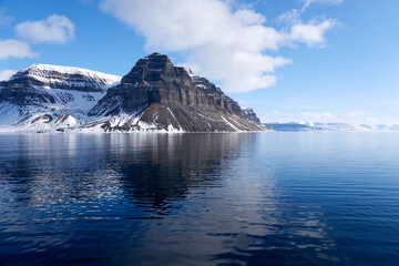 Obraz premium Svalbard. Snow in late spring. Midnight sun. Snowmobiles and Boats. Sun and clouds. Glaciers. North Pole. Ice and Iceberg. Ice caves. Reindeers. Norway.