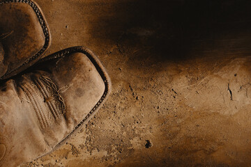 Cowboy boots on old vintage texture background for western wallpaper with copy space.
