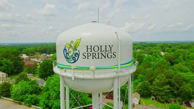 Drone Pull Away shot of Holly Springs Water Tower Revealing Town in Background