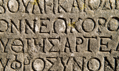 Ancient greek background with greek letters carved in stone. 