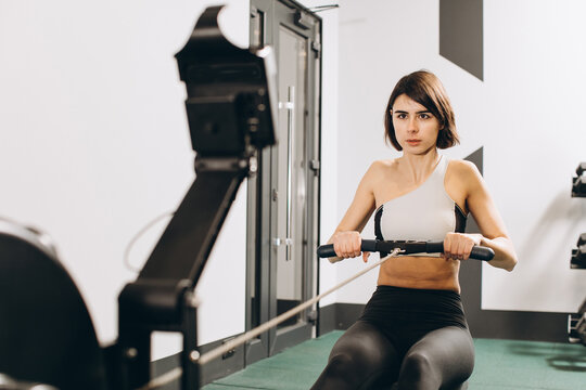 Woman exercising on rowing machine, part of circuit training warmup cardio session