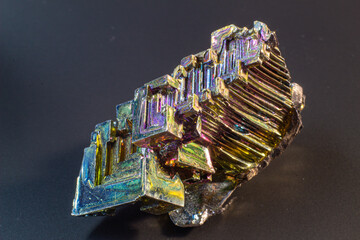 Bismuth bi close up on black surface.Interesting colour and shape crystal. Metal crystal
