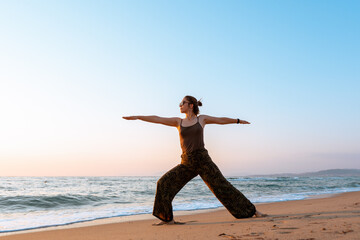 Beautiful woman doing yoga on the beach with copy space