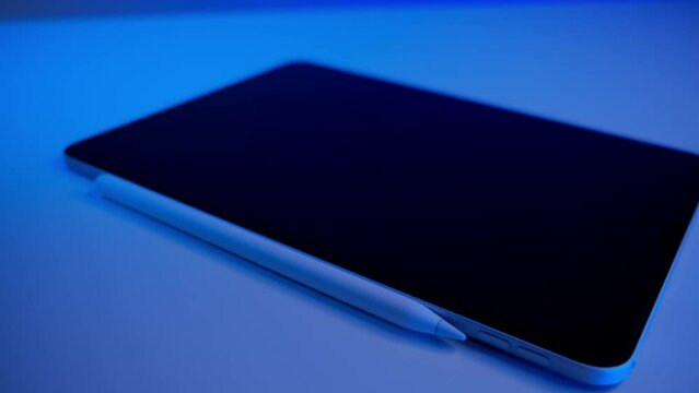 tablet with pencil on blue background