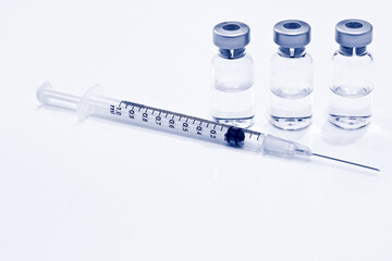 Vial of Drug or Vaccine and 1 ml Plastic Syringe with Needle Isolated on the White Background, blue tone color