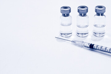 Vial of Drug or Vaccine and 1 ml Plastic Syringe with Needle Isolated on the White Background, blue tone color