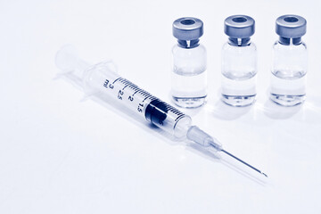 Vial of Drug or Vaccine and 3 ml Plastic Syringe with Needle Isolated on the White Background, blue tone color