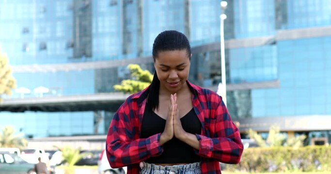 Close up portrait african calm girl folds palms in front bows namaste greeting prays.