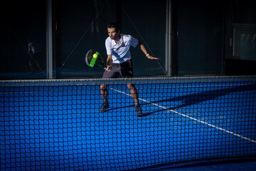 Man playing padel tennis indoor