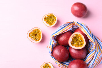 Passion fruit in fabric bag on pink, Tropical fruit in summer season