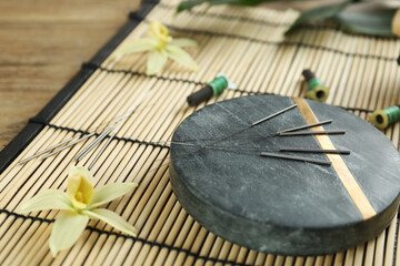 Composition with acupuncture needles on bamboo mat
