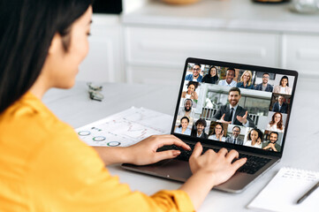 Virtual meeting, brainstorm of colleagues, online conversation. Over shoulder view of a girl to a...