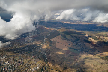 Aerial view at high altitude of earth covered with puffy cumulus clouds forming before rainstorm