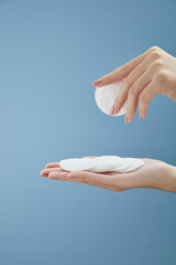 Topview of hand model using makeup remover on cotton pad in blue background for cosmetic advertising   © Tuan  Nguyen 