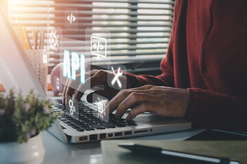 API - Application Programming Interface, Woman using laptop computer with VR screen API icon on office desk, Software development tool, modern technology, internet and networking concept.