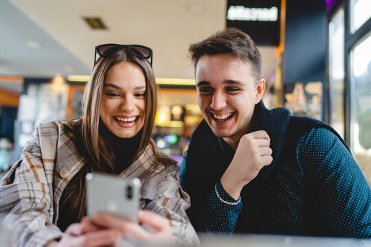 Two people young caucasian couple man and woman female and male friends or boyfriend and girlfriend taking selfie photos or making a video call while sitting at cafe copy space fun and romance
