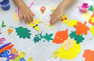 Autumn crafts. Child making colorful fun leaves from paper and plasticine. Back to school. Ideas...