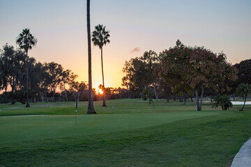 View of golf course with sun setting on the background.