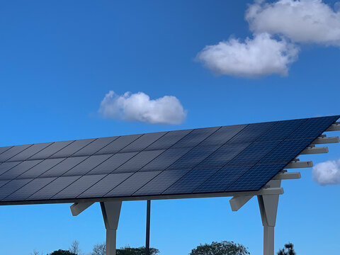 Car port with solar panels with blue sky background.