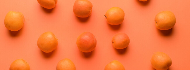 Many ripe apricots on orange background, top view