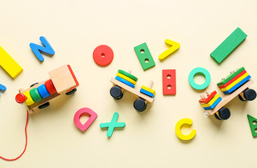 Toy train with building blocks and letters on beige background