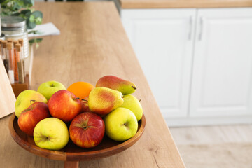 Tray with fruits on wooden counter in kitchen
