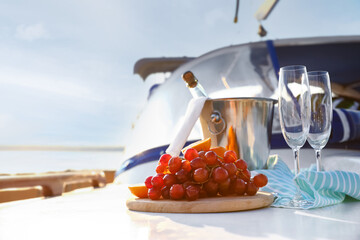 Fresh fruits with cold champagne on deck of yacht