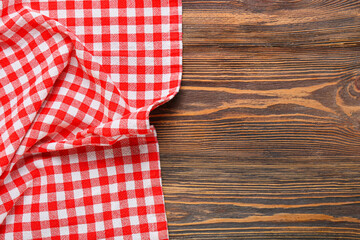Red checkered tablecloth for picnic on wooden background