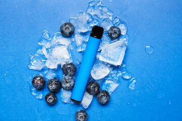 Disposable electronic cigarette, blueberries and ice cubes on blue background