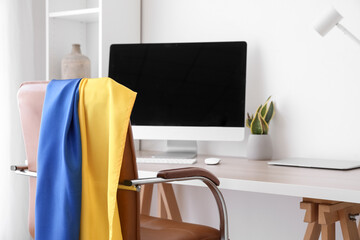 Flag of Ukraine on chair in modern office