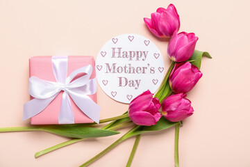 Card with text HAPPY MOTHER'S DAY, tulips and gift on pink background