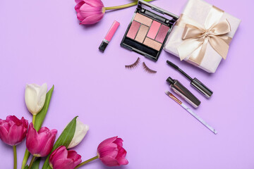 Violet tulips, gift box and decorative cosmetics on color background