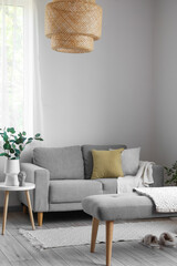 Interior of light living room with soft bench, sofa and houseplants