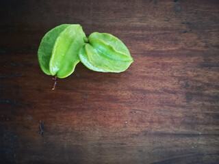Green carambolas on wooden background 2