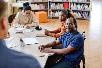 Modern family of Black migrants attending language lesson in international school listening to...