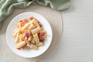 spaghetti rigatoni pasta with white sauce and bacon