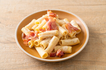 spaghetti rigatoni pasta with white sauce and bacon