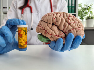 Nocebo effect concept. Female doctor holding brain model and placebo supplement pill - obrazy, fototapety, plakaty