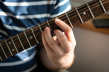 Fototapeta premium A man plays electric guitar. Macro photo. Front view.