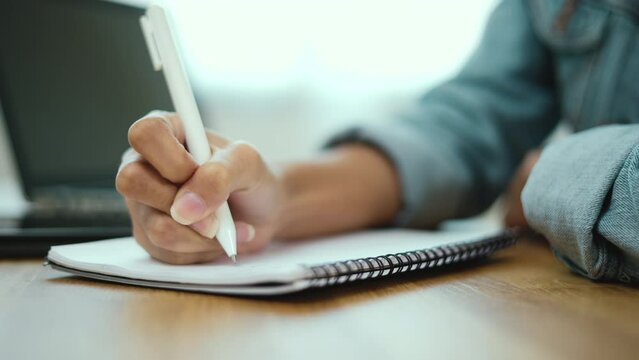 Close-up hand Creator woman take notes your idea at home. Business woman holding pens and papers on table. Student doing homework after studying online.
