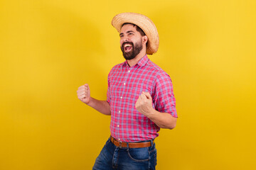 Bearded man wearing typical clothes for party Junina. Celebrating, cheering victory, joy and...