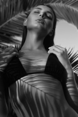 Naklejka premium beautiful summer girl under palm. Beauty black and white Portrait