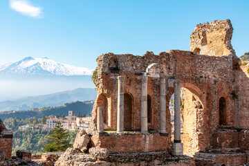 Fototapeta na wymiar Panoramic view of snow capped Mount Etna volcano on a sunny day seen from the ancient Greek theater of Taormina, island Sicily, Italy, Europe, EU. Travel destination at the Mediterranean sea. Tourism